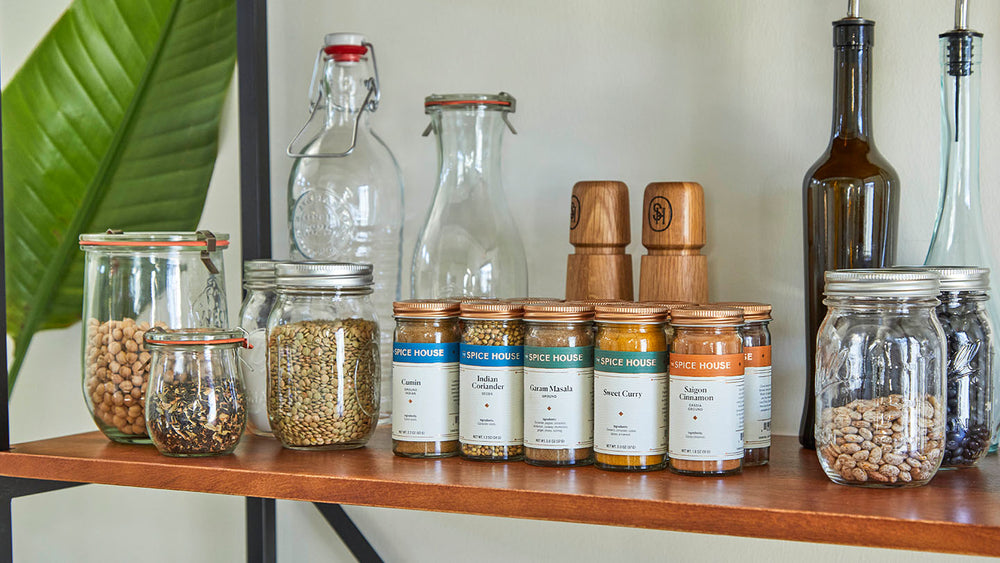 Spices in jars next to pantry staple ingredients