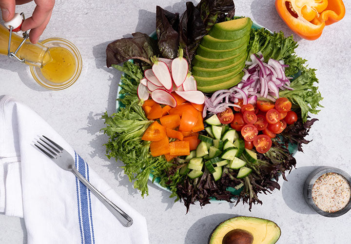 Mixed green salad with vegetables in a bowl