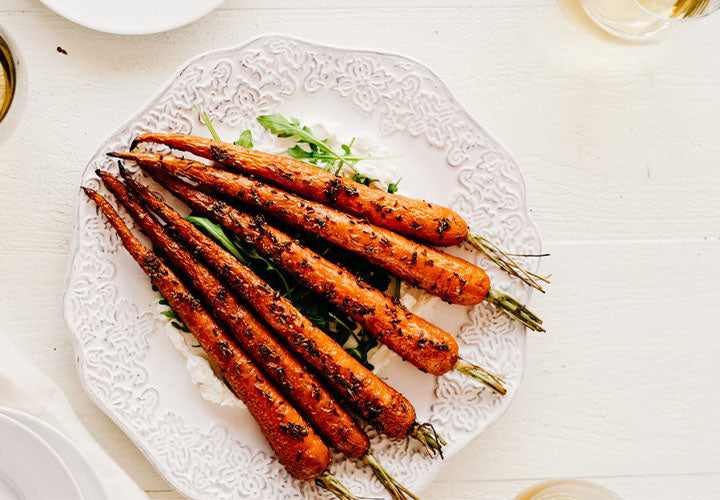 Spice roasted carrots are topped with fragrant coriander, anise, and caraway seeds then served over fresh ricotta with arugula.